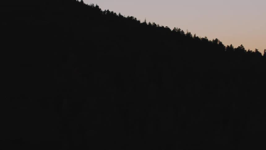 Aerial of a forested mountain range at dusk