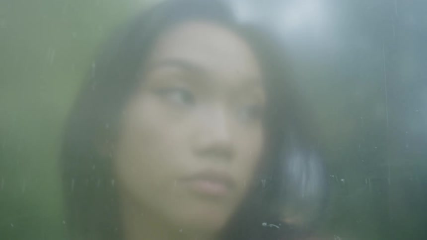 Dirty lens occasionally blurs closeup of a woman standing outdoors