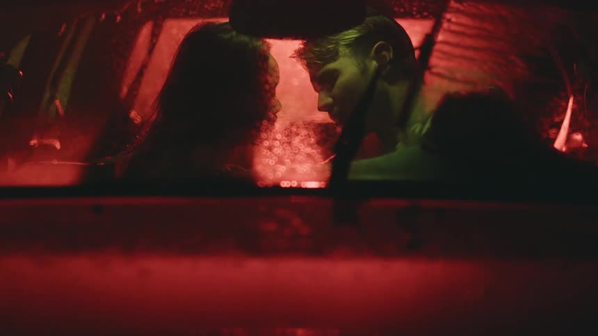 View from the windshield of a car and a couple and a romantic atmosphere on a rainy day at night