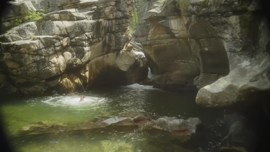 A man jumps off the cliff into the water