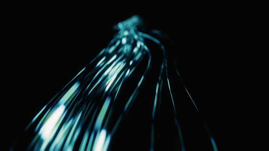 Blurry streaks of blue light and data twist and bend as they move in the darkness