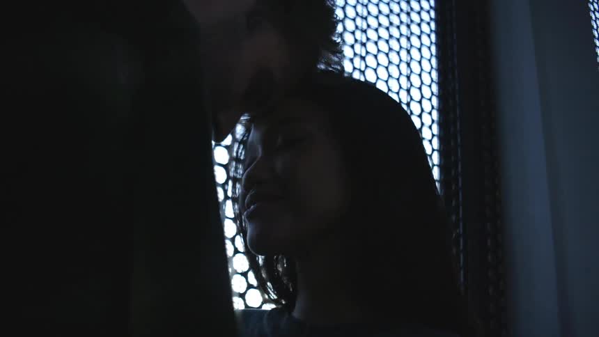 A couple lean into each other by the window