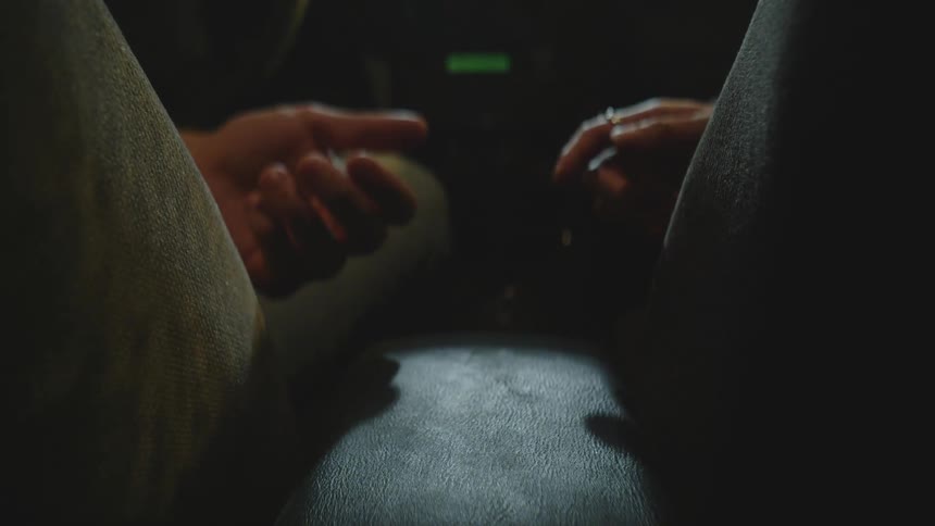 Two people touch hands in the car