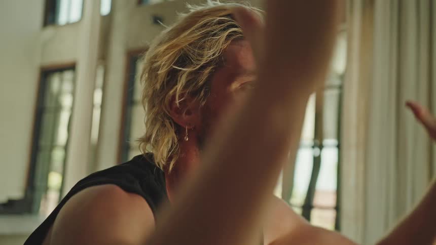 Portrait of a blond man with his hands up and palms together