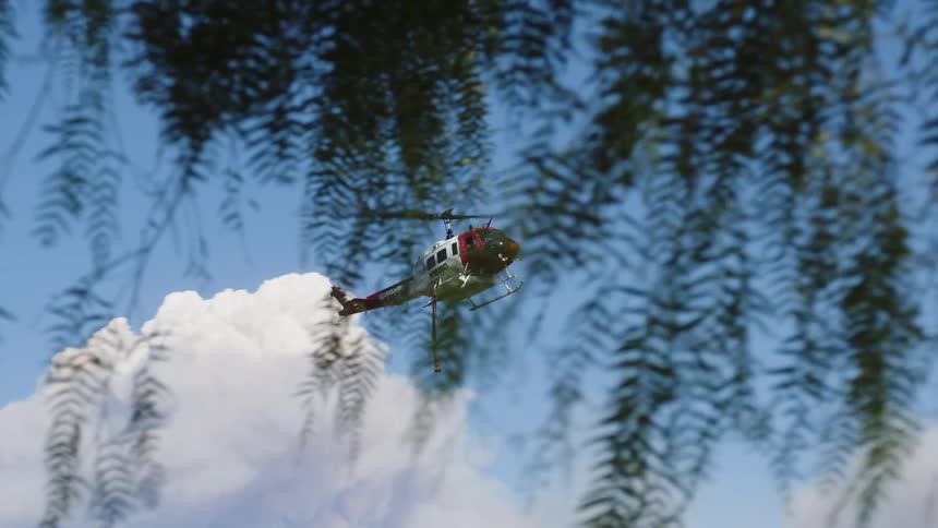A police helicopter flies high over the mountains