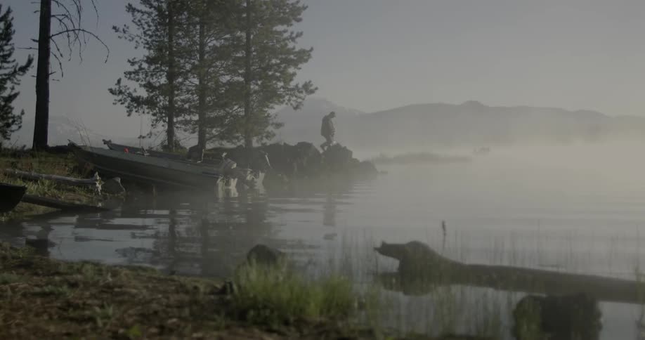 A person walks to the edge of a lake