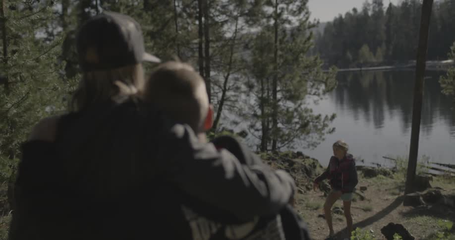 A man and woman hugging near a lake