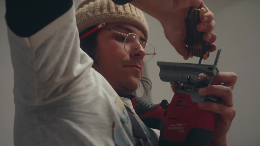 Man uses a multi tool to work on a powered handheld tool