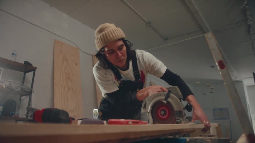 Carpenter using a makita closing a wooden sheet on the table