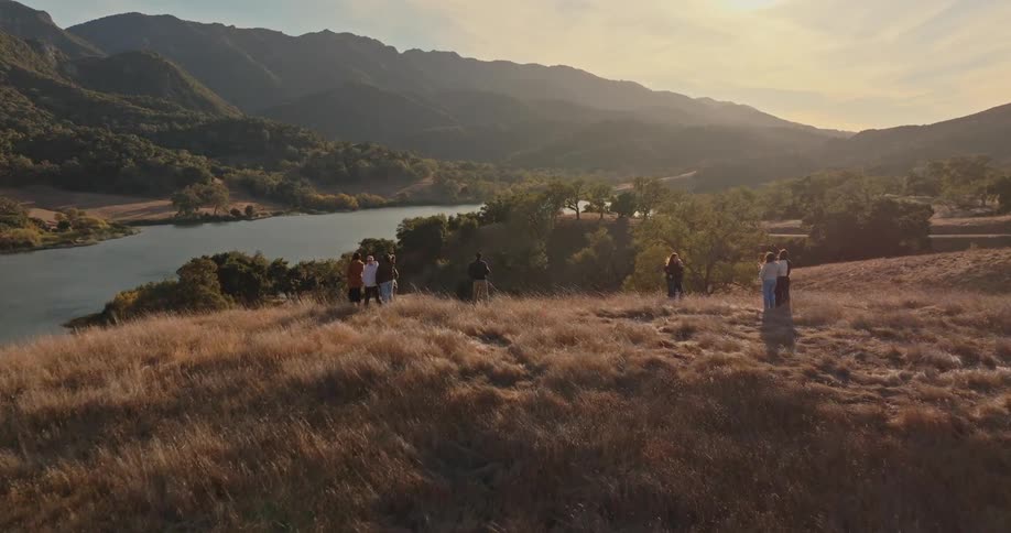 Groups of people and families on a hill by a lake