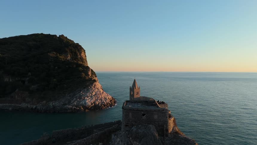 Coastal view with a historic church positioned on a rocky cliff by the sea