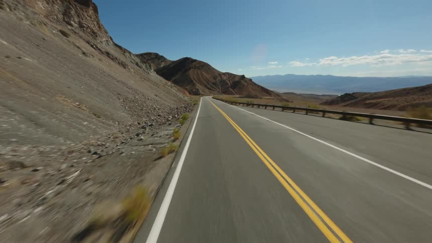 A winding road cuts through a barren desert landscape