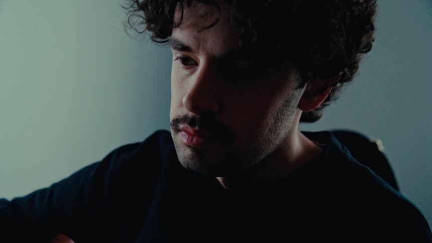Portrait of a curlyhaired man playing a musical instrument