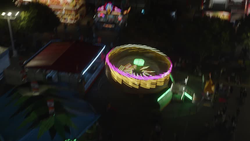 Aerial of a carnival ride spinning super fast at night