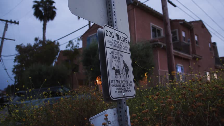 Sign on the street with a house in the background