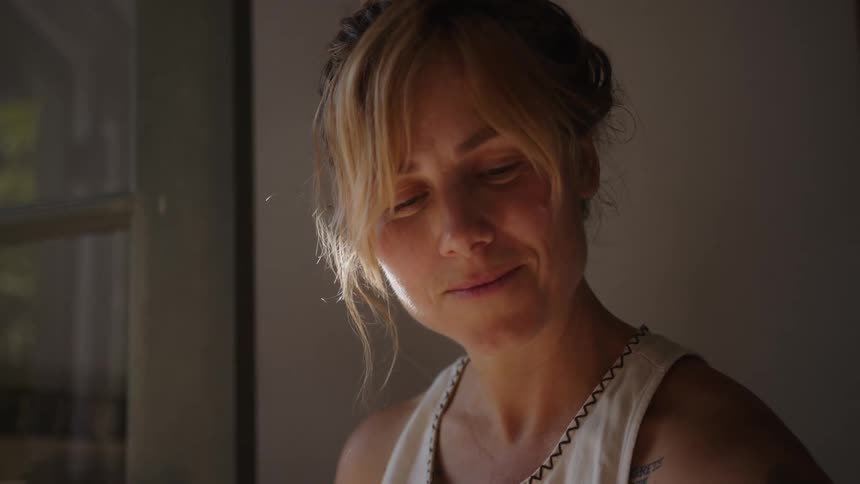 A woman is smiling by the window