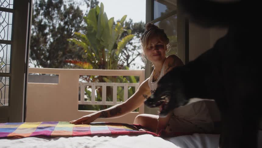 Dog lying on the bed next to a woman