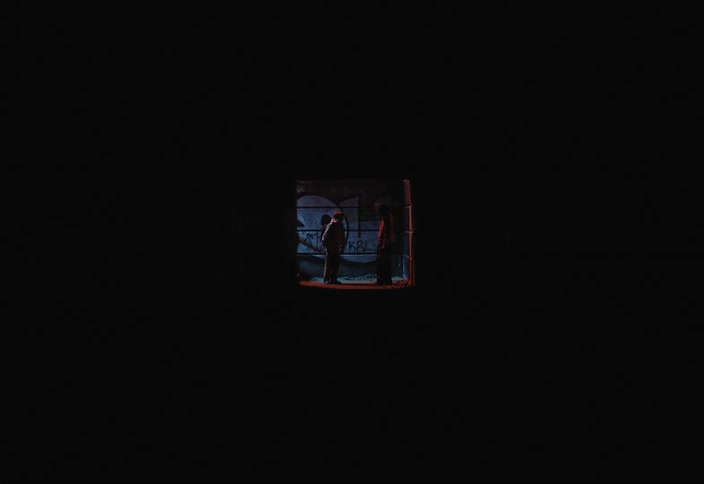 Two boys in a dark hallway talking