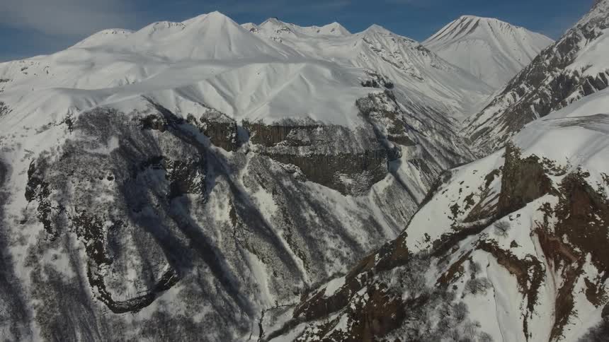 Snow covered mountains with steep slopes and rough terrain