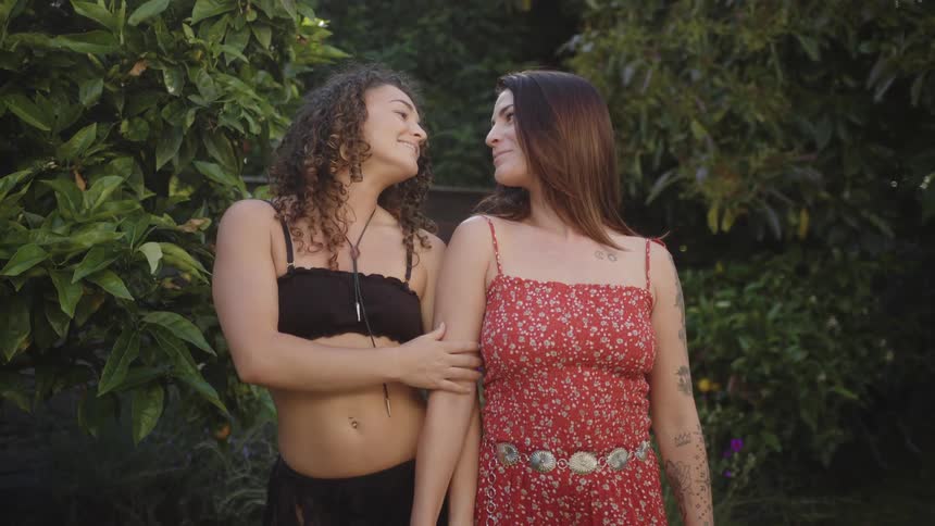 Two women hold hands and smile