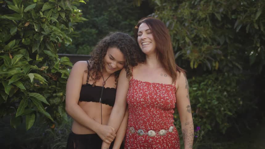 Couple of two women outdoors together side by side