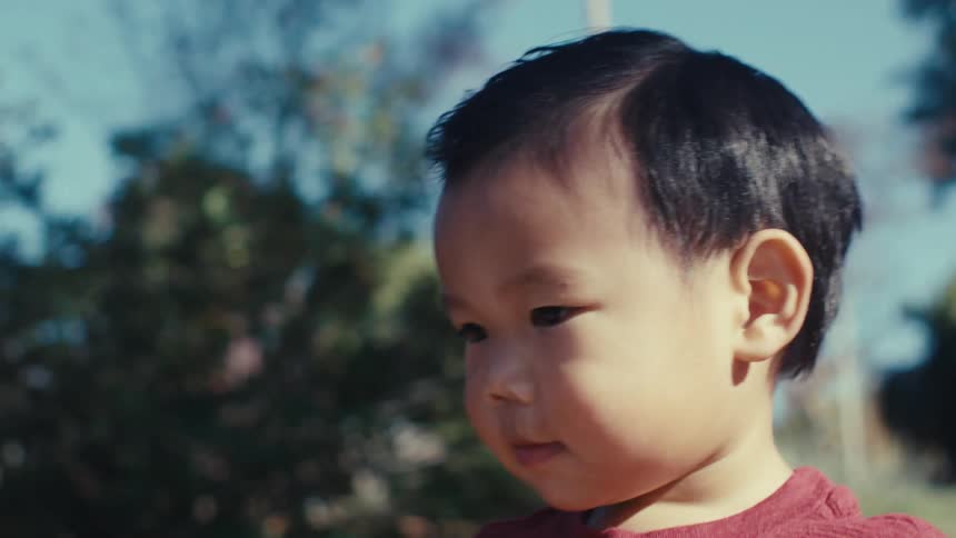 Little boy walking on an outdoor trail and mother picks him up and gives him a kiss