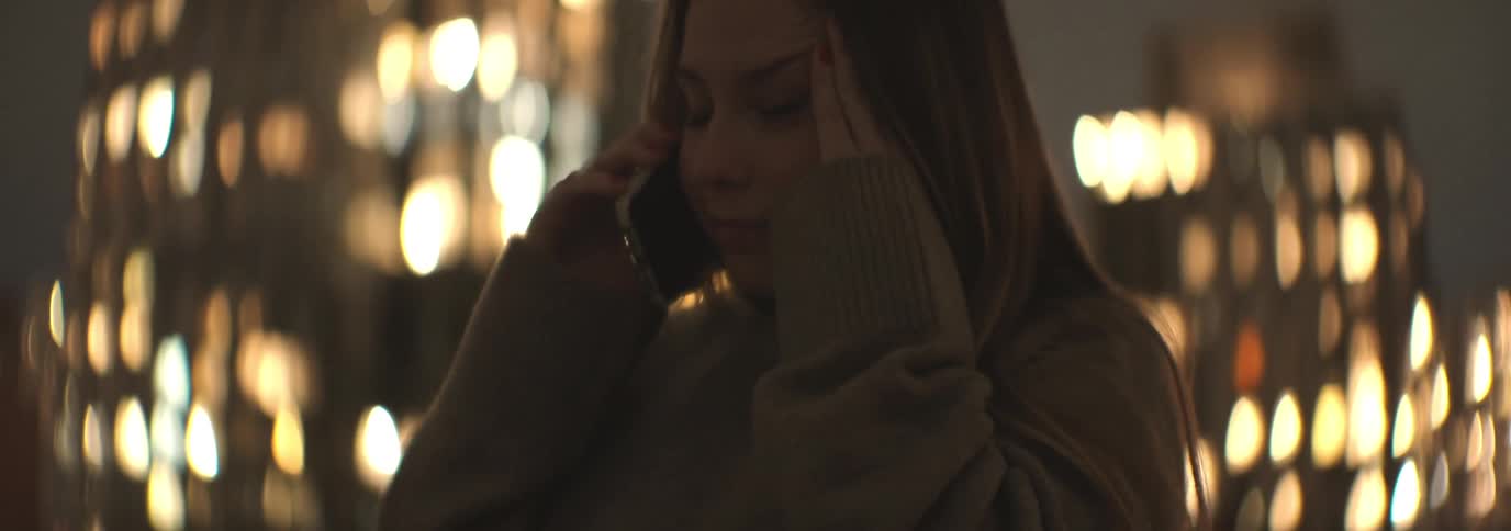 Woman rubbing her face while on a phone call