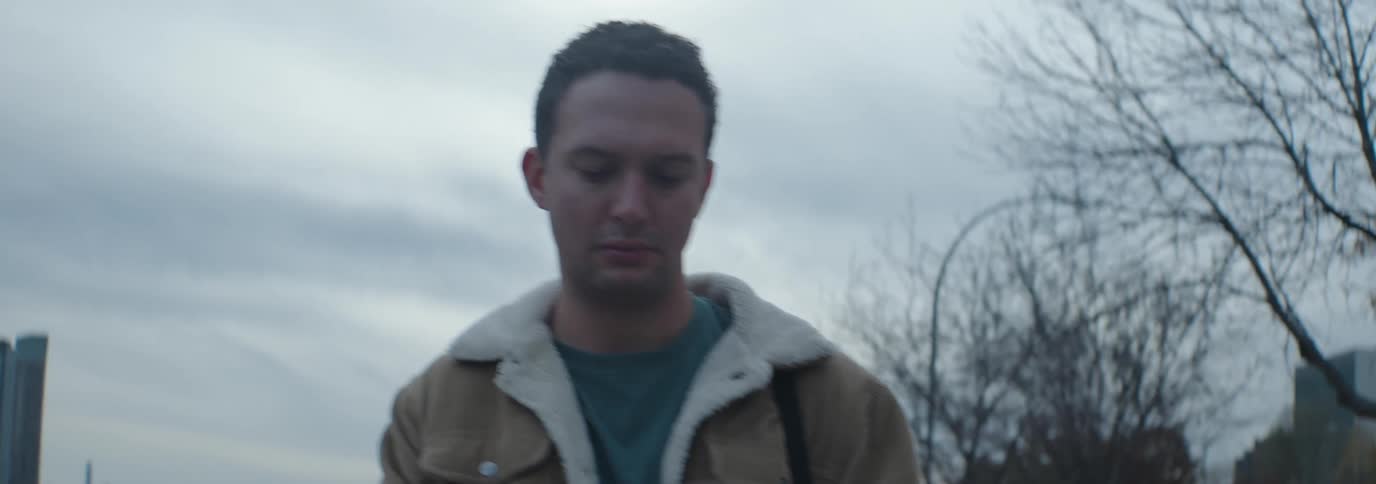 Man walking outdoors and typing on a smartphone