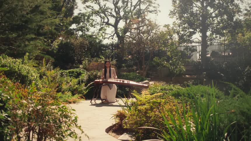 A woman is playing a musical instrument in the garden