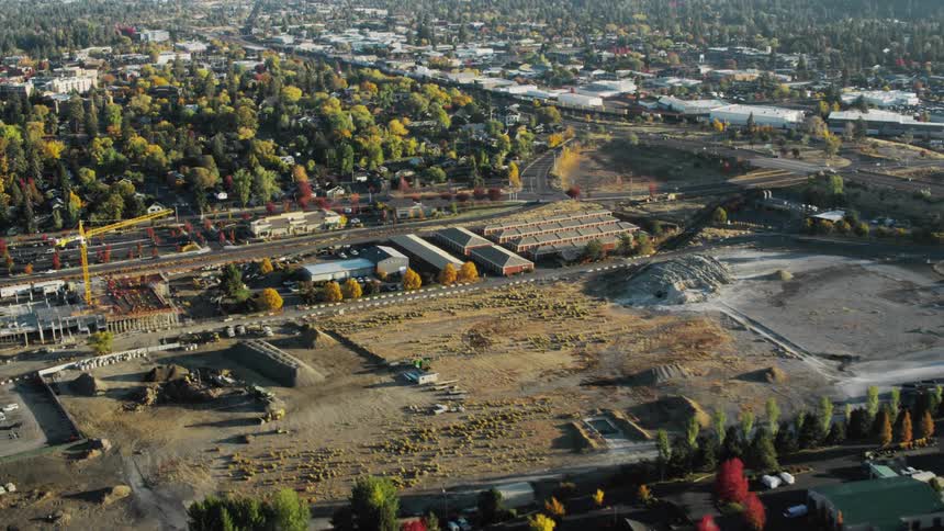 Aerial panorama of an urban city and factories in the background surrounded by vegetation