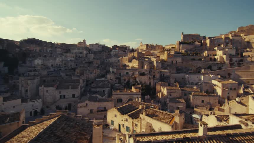 A breathtaking panoramic view of a historic town nestled on a hillside with numerous buildings constructed directly into the rock face