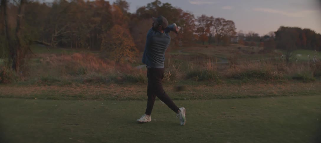 Man taking a golf swing on a course