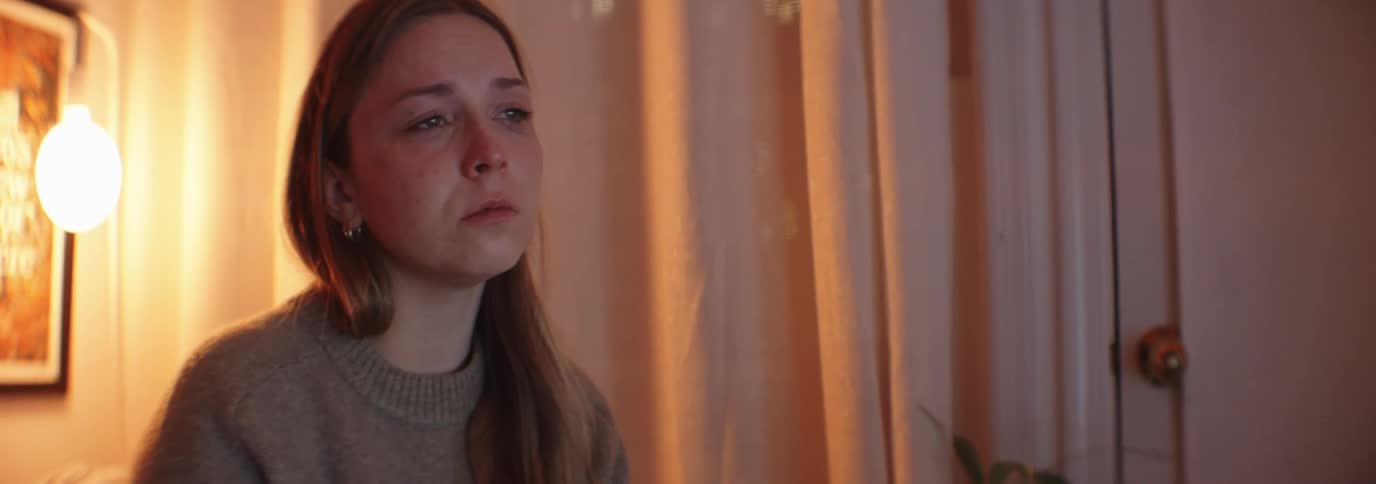Woman sitting in a room concentrating and with a sad facial expression