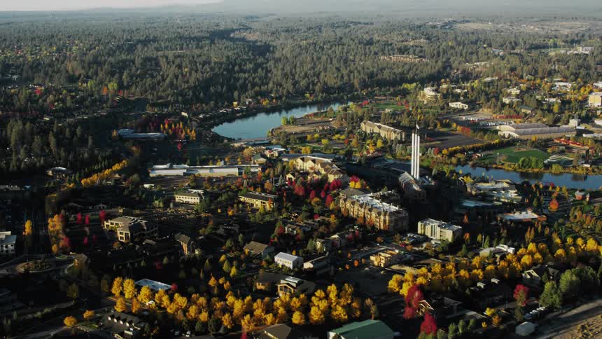 Aerial view of a factory in the middle of a wooded area with lakes