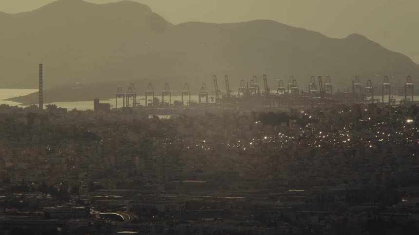 Urban landscape with a seaside port in the background and mountains on the horizon
