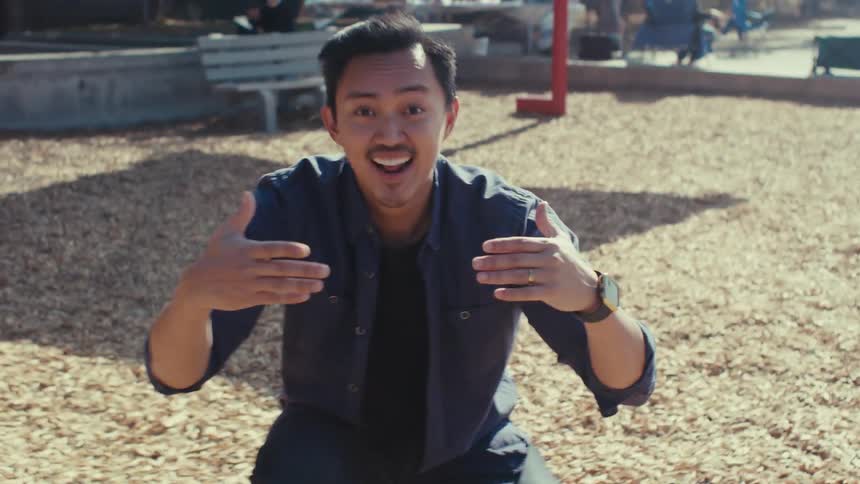 Happy man on an outdoor playground calling out to a person with gestures