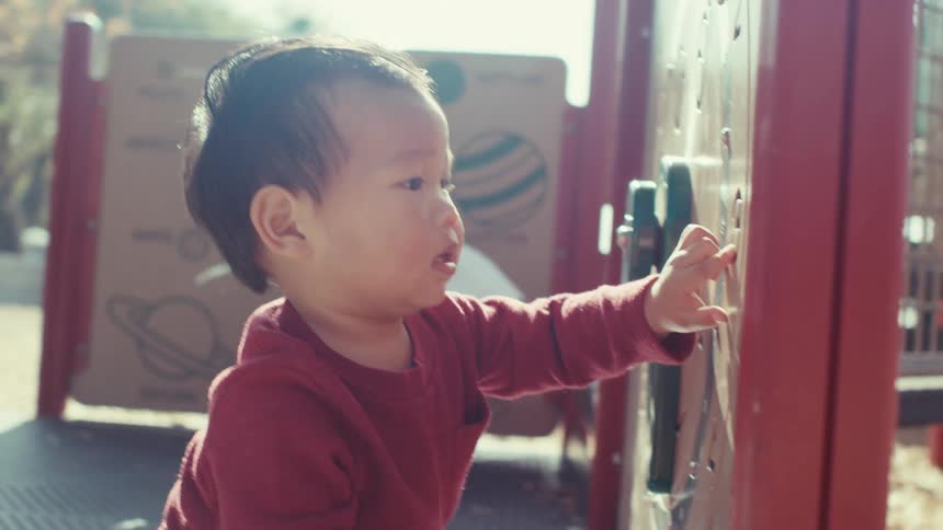 Mother watching her little son playing in a playground