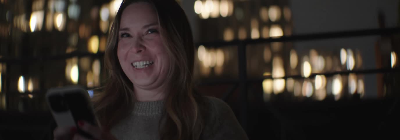 Woman laughing while interacting with a smartphone