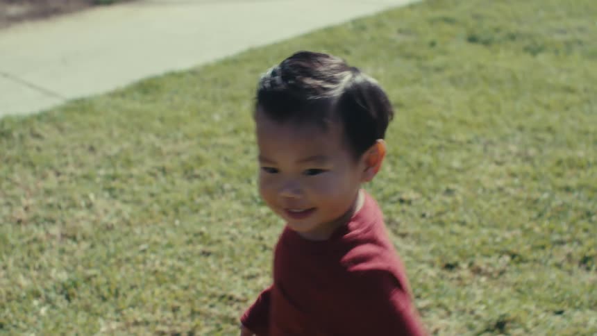 Boy outdoors running through grass