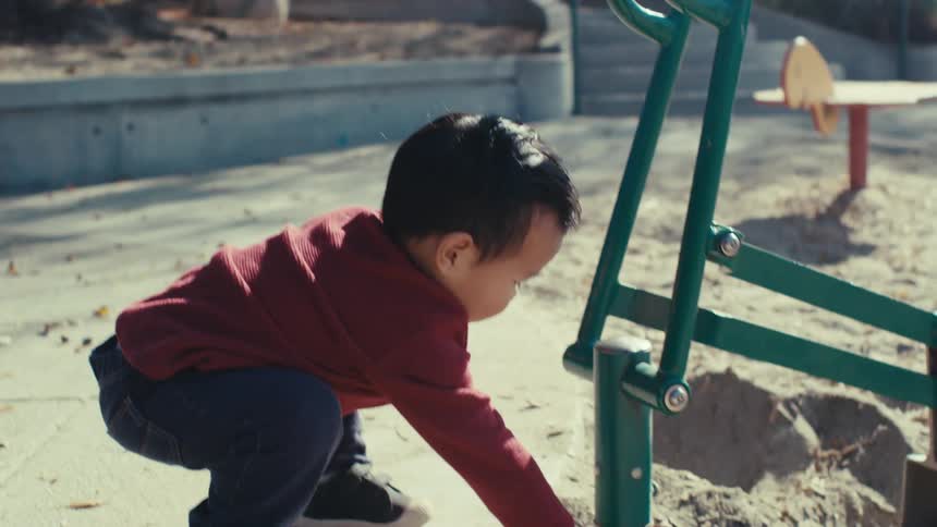 Little boy playing with sand in an outdoor playground
