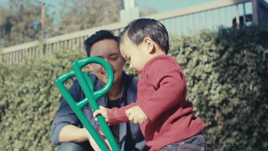 Father with his little son playing in a sand playground