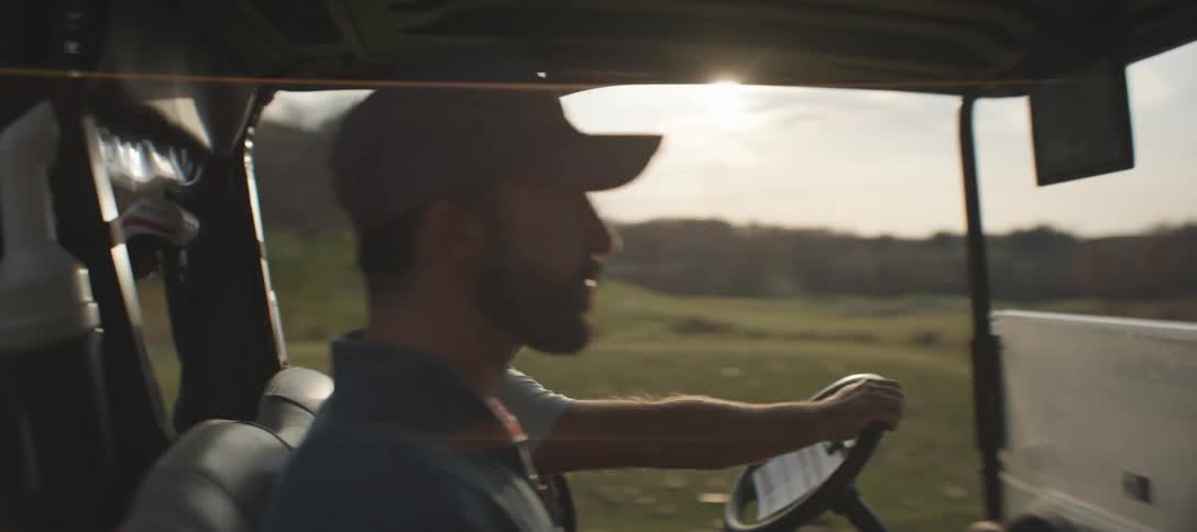 Two men ride down a path on the golf course