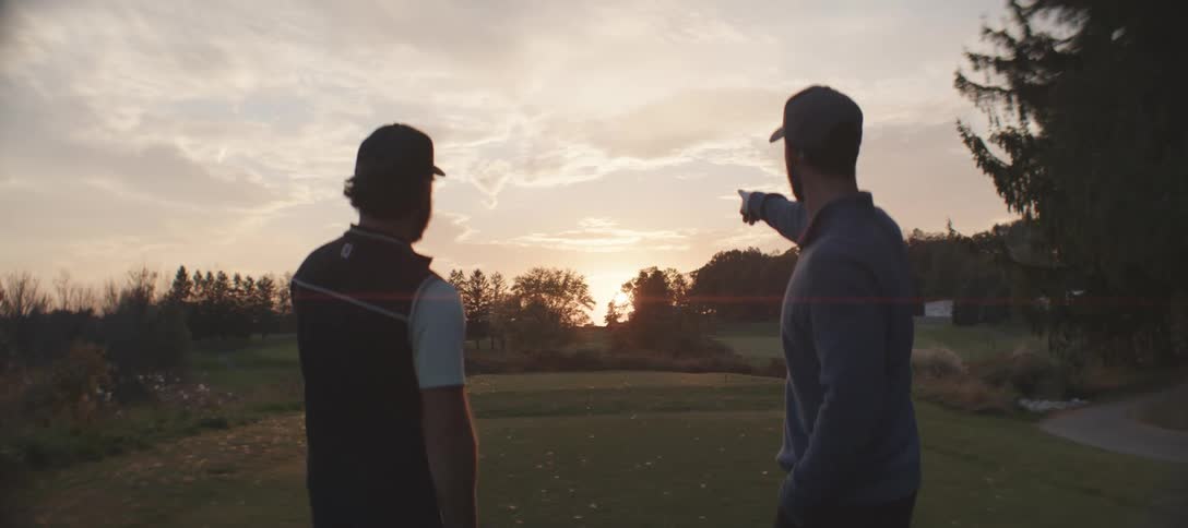 A clip of people playing golf and pointing to the horizon
