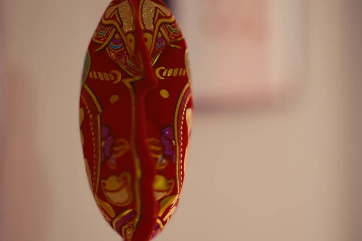 Close up of a small red asian plush object spinning