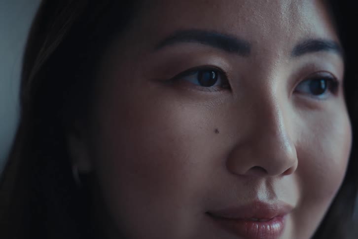 Close up of the face of an asian woman in a well lit room