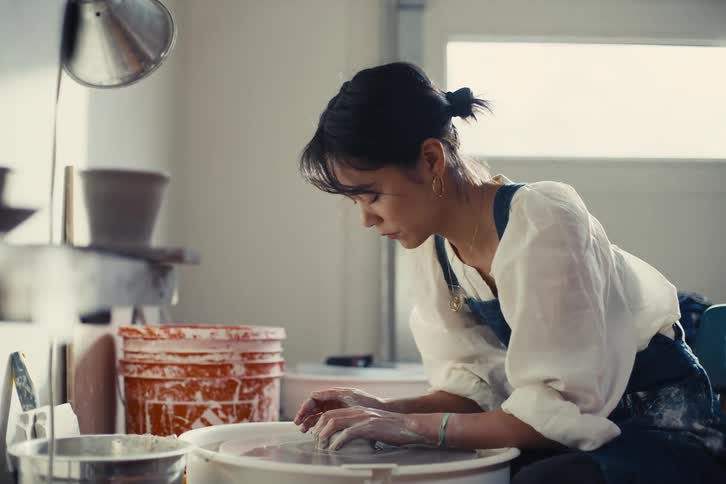 A leaning forward sculpting clay