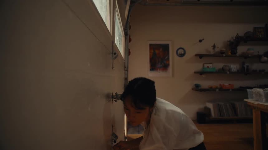 Woman closing the door of a garage that leads to the house