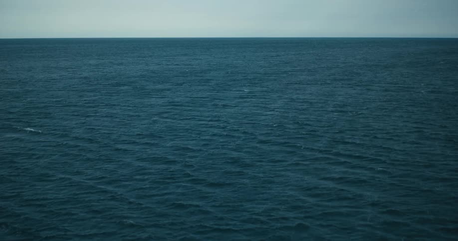 A vast expanse of deep blue ocean with gentle waves rippling across its surface