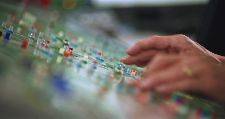 Pair of hands operating a control panel clicking buttons