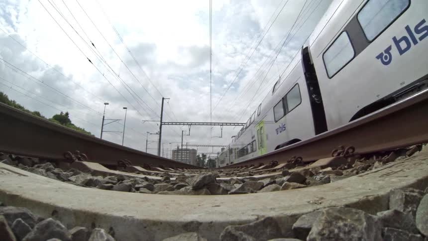 Train passing through the railroad on an area surrounded by buildings outdoors during daytime
